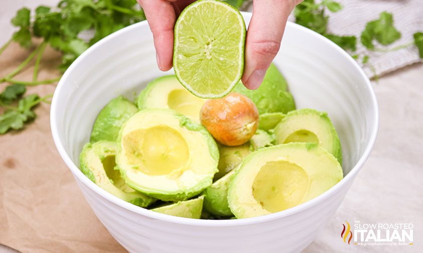 squeezing lime over avocado flesh